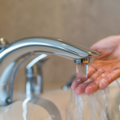 Imagem de mão masculina em pia, demonstrando a necessidade de reutilizar água